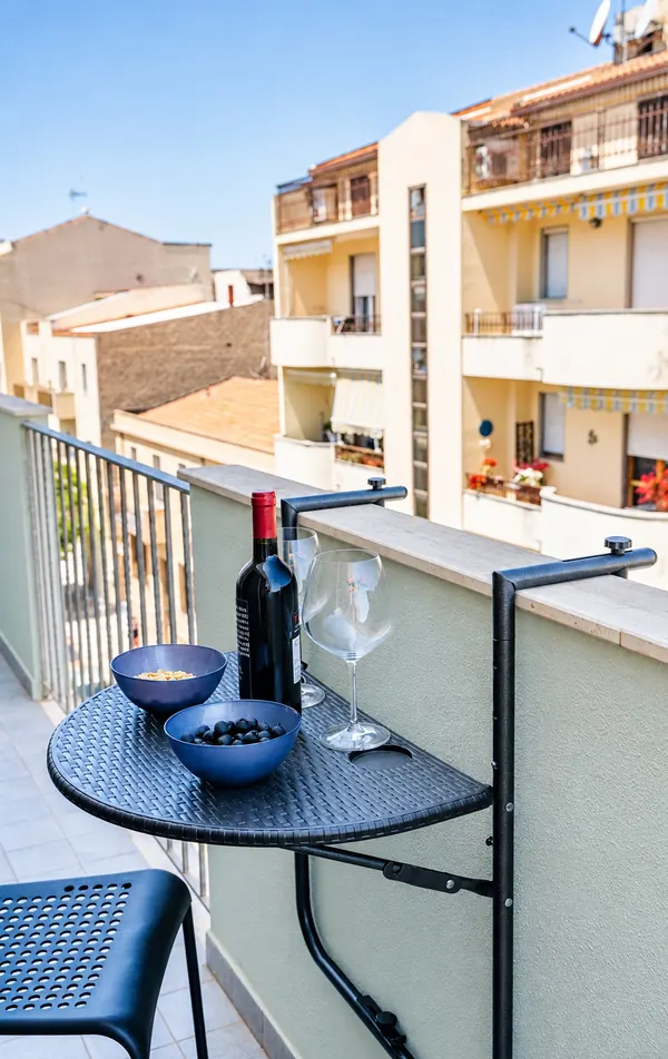 Il balcone: tavolino con vino e olive, vista sulle case