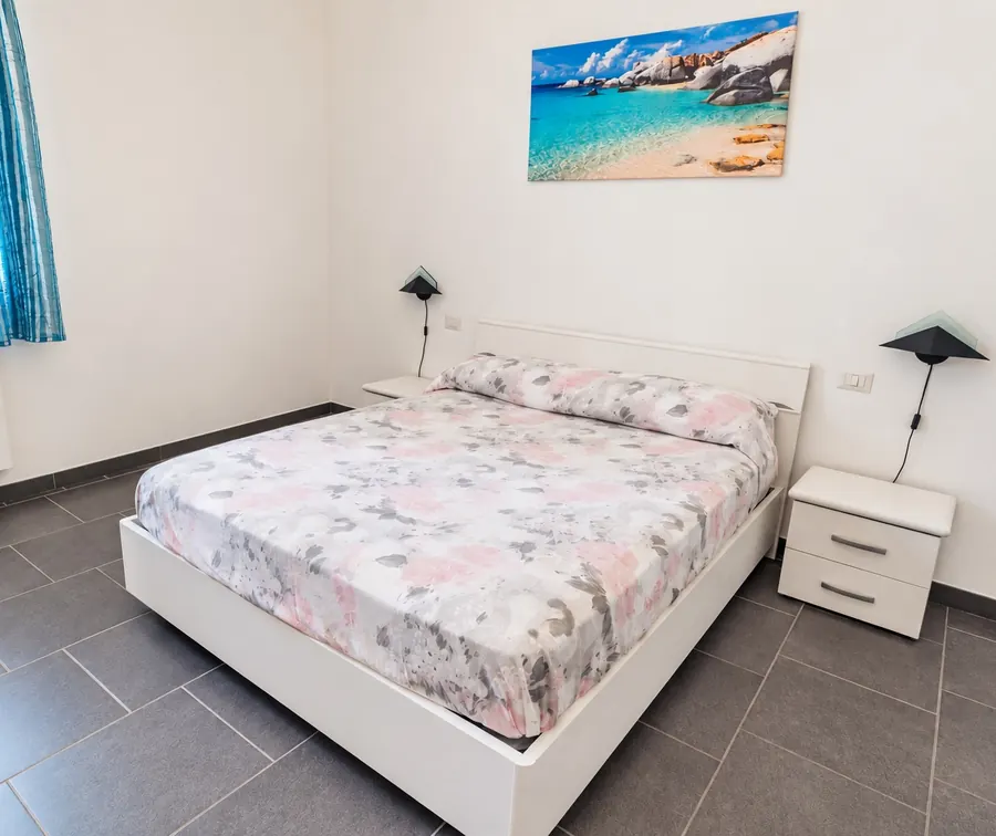 La camera matrimoniale, con il quadro del mare sopra il letto
