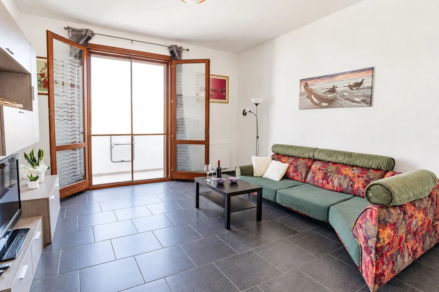 Il soggiorno con il divano e la porta-finestra sul balcone
